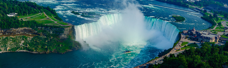 Niagara Falls. USA, 25th August 2022 - A man taking a selfie in front of the strong rapids of Niagara Falls