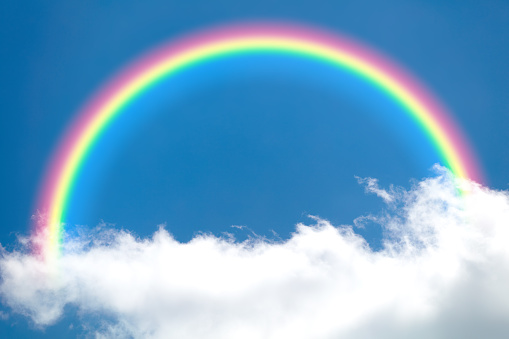 Distant view of a multi-colored rainbow due to rain in summer, bad weather. This image was taken near Ambronay small village of Bugey mountains in Alps, near Jura massif, in Ain, Auvergne-Rhone-Alpes region in France.