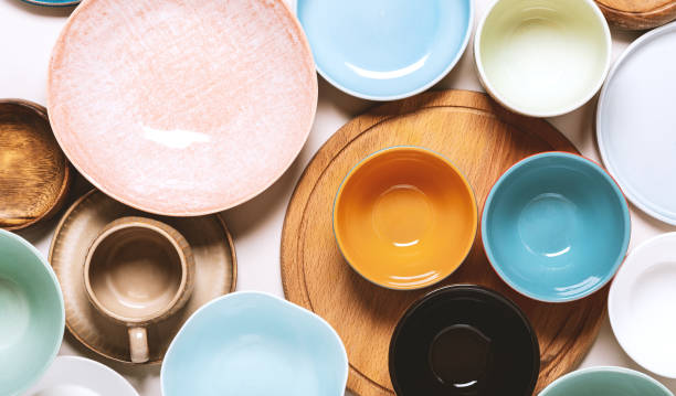 istock Many different ceramic plates and bowls on a light background, top view. 1253678833