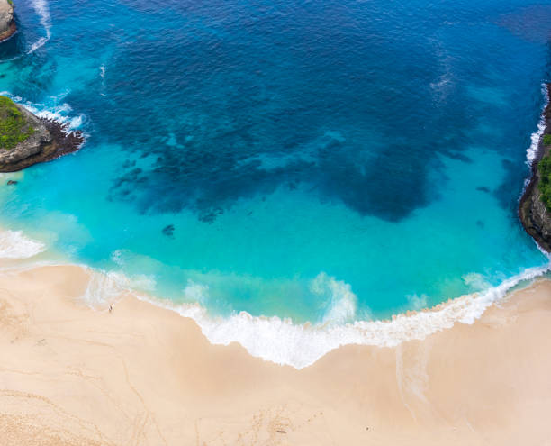 praia de areia klingung com céu azul água do oceano de vista aérea. a praia de klingung está separada de uma viagem de um dia do leste na ilha de nusa penida, regência de klingung, ilha de bali, indonésia - traval - fotografias e filmes do acervo