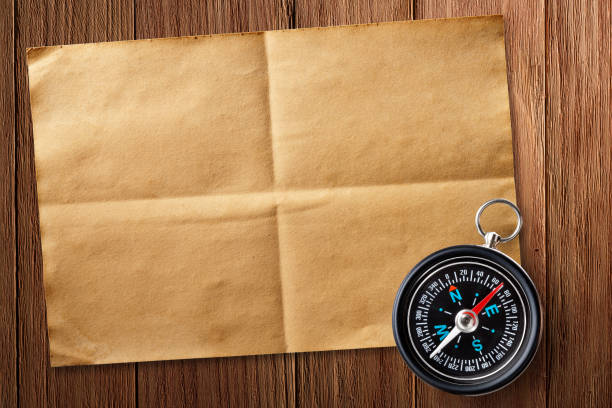 Compass and Old Paper on a Wooden Table