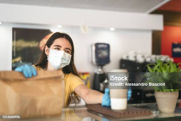 Bar Owner Working Only With Take Away Orders During Corona Virus Outbreak Young Woman Worker Wearing Face Surgical Mask Giving Meal To Customers Healthcare And Food Drink Concept Stock Photo - Download Image Now