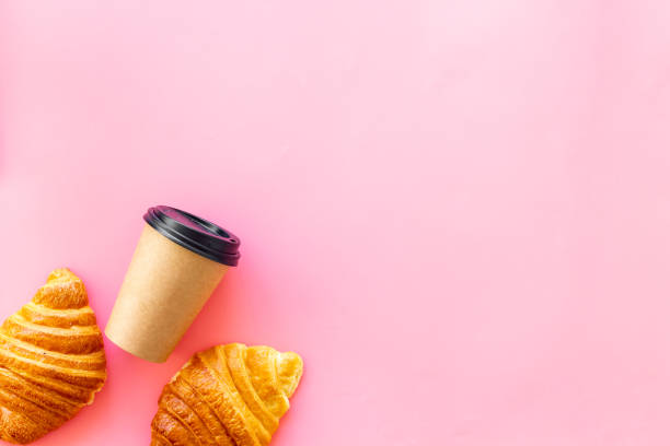 istock Croissants with coffee - breakfast on pink table top view 1253688752