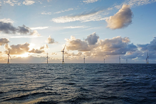 Large offshore wind farm on the horizont in sunset in north Sea