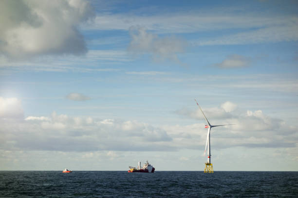 Large boat - transfer vessel, offshore 8MW wind turbines and rescue boat - jetty on the horizont in north sea with dramatic skyon Large offshore 8MW wind turbines, wind farm on the horizont in north sea gran barco - buque de transferencia, turbinas eólicas offshore de 8mw y barco de rescate - embarcadero en el horizonte en el mar norte con espectacular skyon grandes aerogeneradores marinos de 8mw, parque eólico en el horizonte en el mar del norte