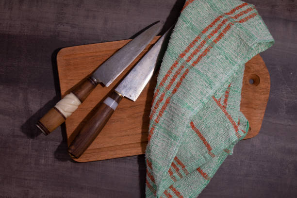 istock Tow Big kitchen knife with wood and handle handle lying on an old cutting board 1253691301