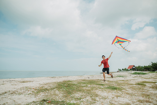 Young man enjoying learning how to fly kite