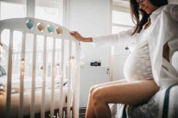 istock Pregnant woman and crib 1253691621