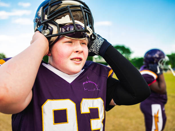 istock Junior Football player getting helmet ready 1253693832