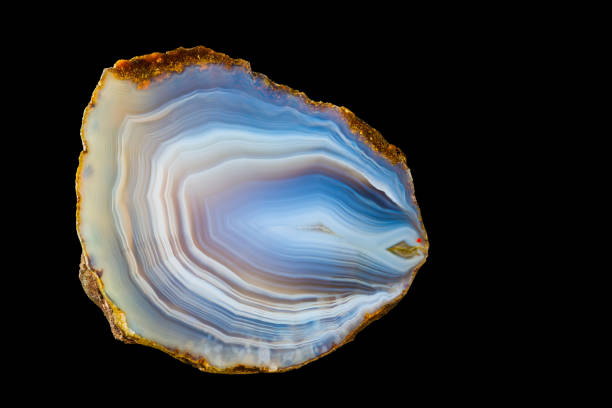 istock Close-up of polished agate gem with smooth icy surface texture isolated on black background 1253693853