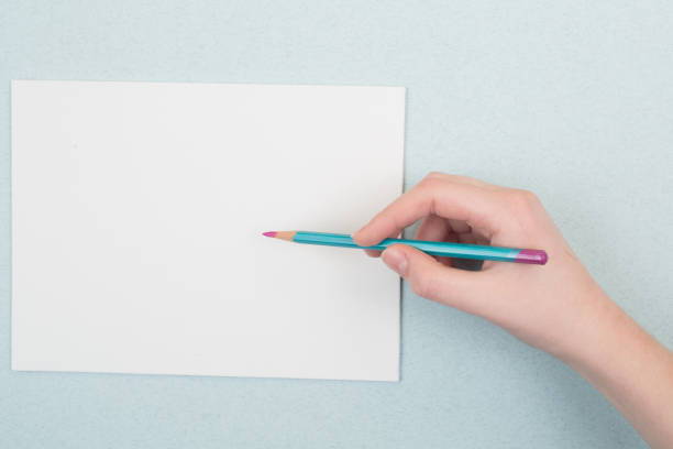 istock pencil in hand on a blue and white background 1253694123