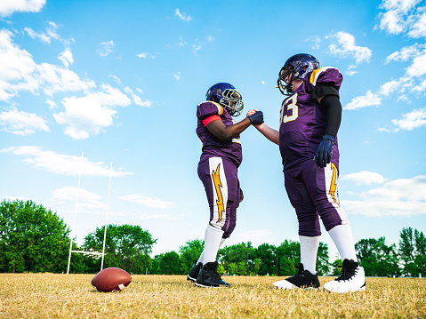 Two Junior Football players during practice game at the outdoor field.