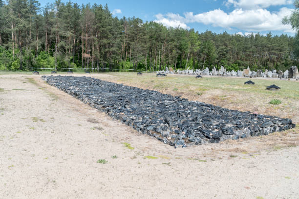 каменный мемориал, напоминающий одну из оригинальных кремационных ям, где были сожжены тела. лагерь смерти треблинка. - treblinka стоковые фото и изображения