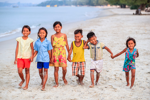 Group of Cambodian children walking together on the beach, Cambodia
