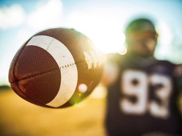 istock Football in the hands during game 1253696286