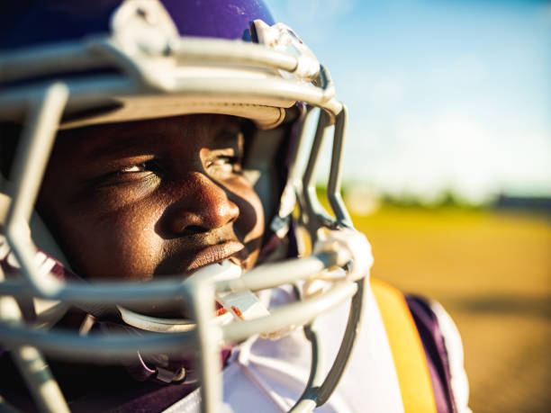 Junior Football player during game African American Junior Football player getting during game practice at the outdoor field. mouthguard stock pictures, royalty-free photos & images