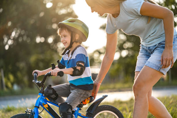 istock Boy learning to ride a bicycle with mother 1253697777