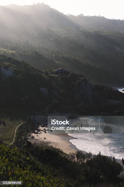 Little Beach In A Valley At Sunset With People Standing At The Sand Stock Photo - Download Image Now