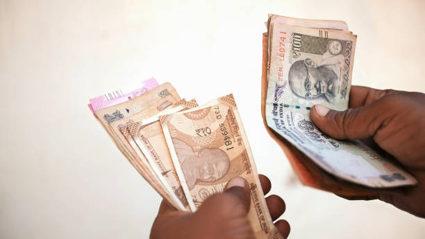 istock Man recounts indian rupee money 1253699102