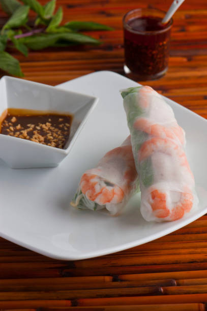 istock Spring-rolls, classic Vietnamese, Thai, Chinese or Korean appetizer. Rice paper filled with vermicelli noodles, shrimp, carrots and shrimp. Served with peanut and spicy sweet and sour sauces. 1253699791
