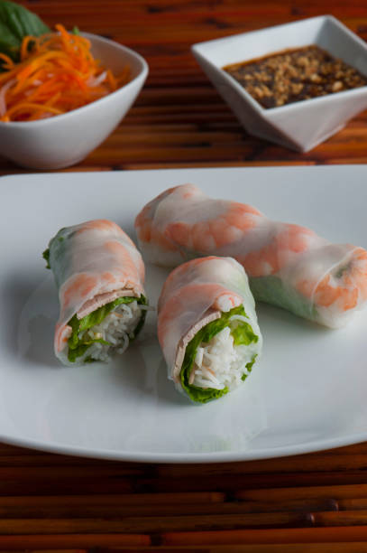 istock Spring-rolls, classic Vietnamese, Thai, Chinese or Korean appetizer. Rice paper filled with vermicelli noodles, shrimp, carrots and shrimp. Served with peanut and spicy sweet and sour sauces. 1253699801