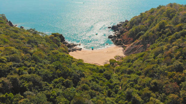 Beautiful secret beach Butterfly in Goa, India. Aerial view of pristine beach with rocky bay and waves crashing Beautiful secret beach Butterfly in Goa, India. Aerial view of pristine beach with rocky bay and waves crashing palolem beach stock pictures, royalty-free photos & images