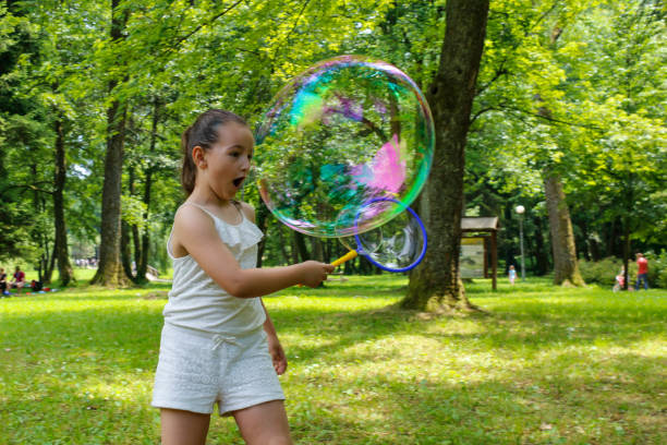 istock Little girl making soap bubbles, Blowing bubbles 1253700123