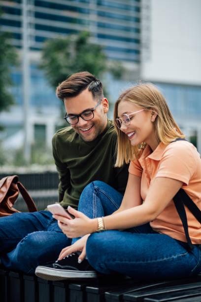 istock Side view of two Caucasian students using a smart phone 1253700476