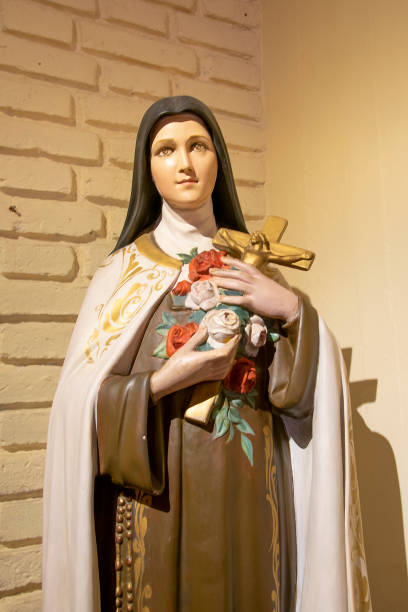 istock Woman Saint Sculpture Holding Cross 1253701761