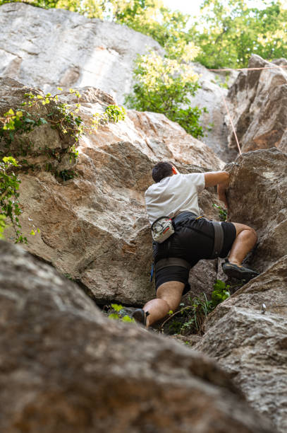 istock Male athlete climbing on the rock mountain 1253702843