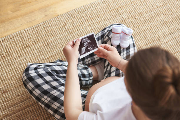 istock Pregnant woman holding ultrasound image 1253704357