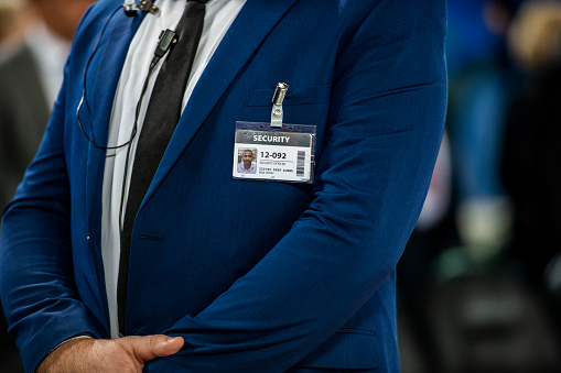 Mid section of security guard standing on basketball court.