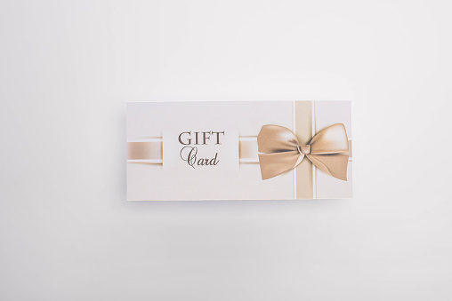 Top view of gift card with bow on white background