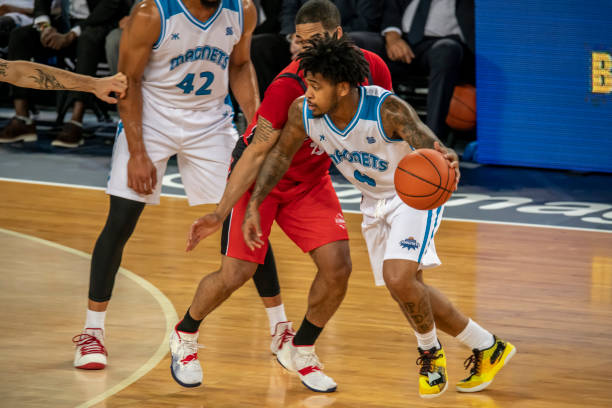 istock Basketball players playing in court 1253707113