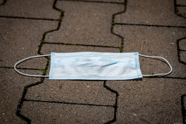 istock thrown away or lost mouth masks on the ground 1253711593