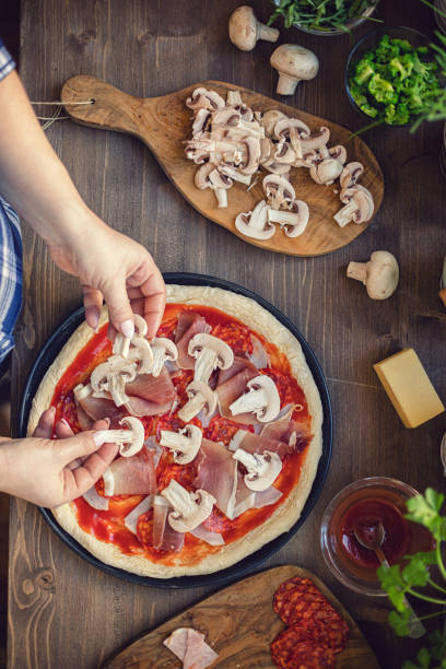 Young women preparing fresh pizza at home