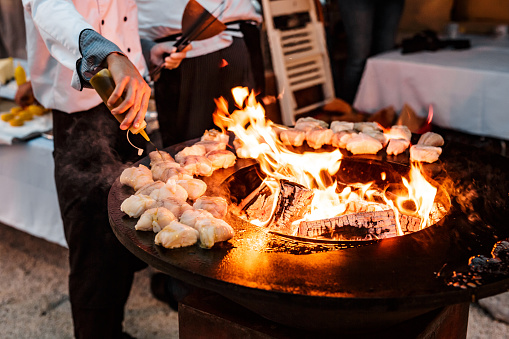 The chef pours sunflower oil pieces of fish steak on the grill. High quality photo