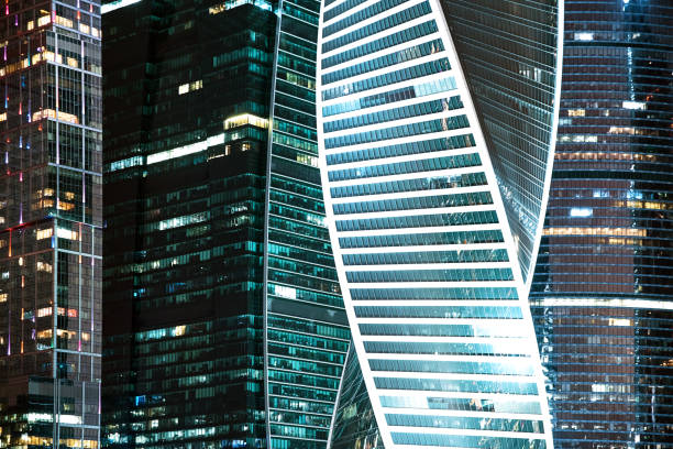 istock Modern glass buildings in business district side view, night light 1253719684