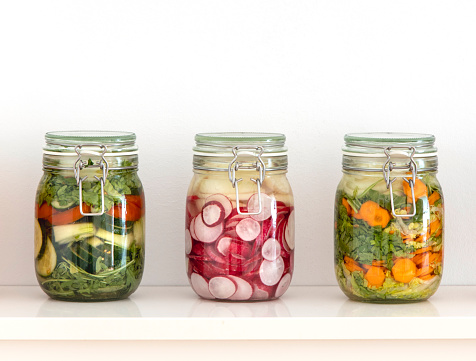 Various fermented vegetables in mason jars on the kitchen shelf