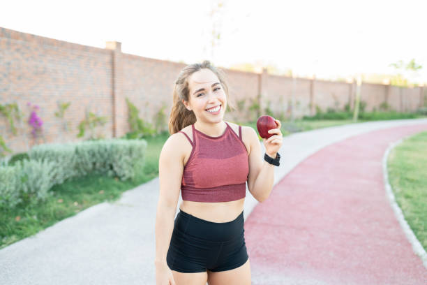 istock Woman Eating Apple After Workout In Park 1253724218