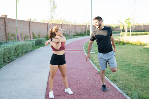 istock Couple Exercising Together In Park 1253724367