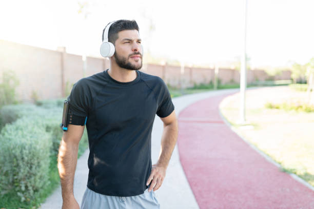 istock Man Listening Music While Working Out In Park 1253725029
