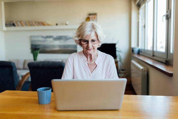 istock Senior woman using a laptop at home 1253726860