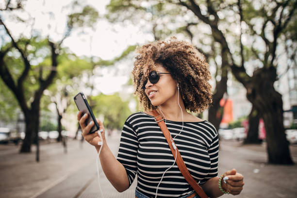 istock Beautiful woman using smart phone on the street 1253727024