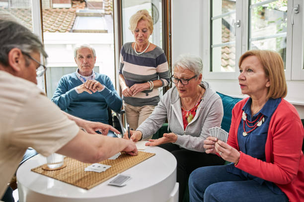 istock Group of seniors having a discussion while playing cards 1253729921