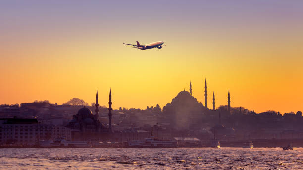 Istanbul at sunset with a passenger airplane. Cityscape of Istanbul with passenger airplane over the ancient downtown. Skyline of Istanbul at sunset with silhouettes of mosques and old buildings at Sultanahmet district. golden horn istanbul photos stock pictures, royalty-free photos & images