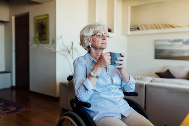 istock Senior disabled woman drinking coffee at home 1253730609