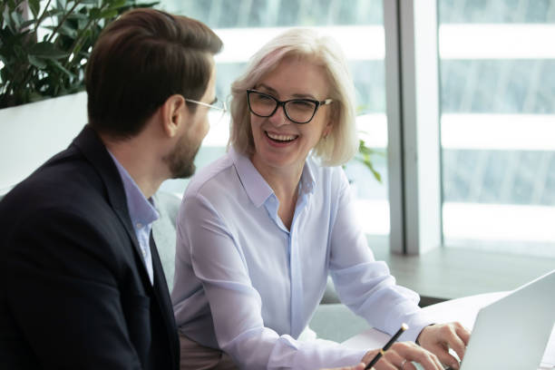 istock Elderly businesswoman sitting next to subordinate 1253731477