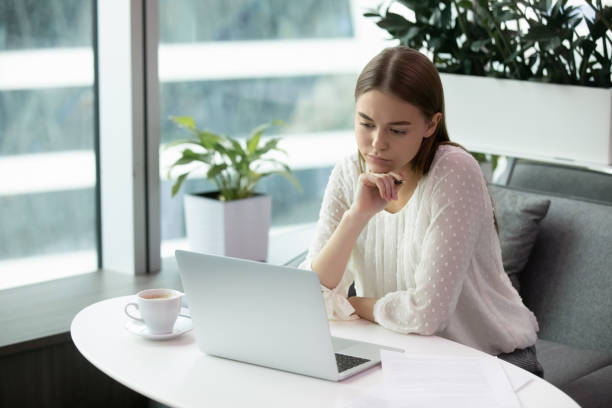 istock Woman worker attentively look at the laptop screen 1253731478