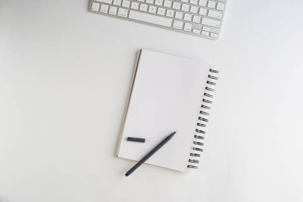 istock Keyboard, notebook and a pen on white background on white background with plenty of copy text space 1253731487